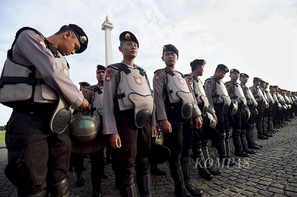 Anggota kepolisian mempersiapkan kelengkapan seragamnya saat mengikuti Apel Gelar Pasukan Operasi Kepolisian Tepusat Lilin-2016 di Lapangan Monas, Jakarta, Kamis (22/12/2016). 