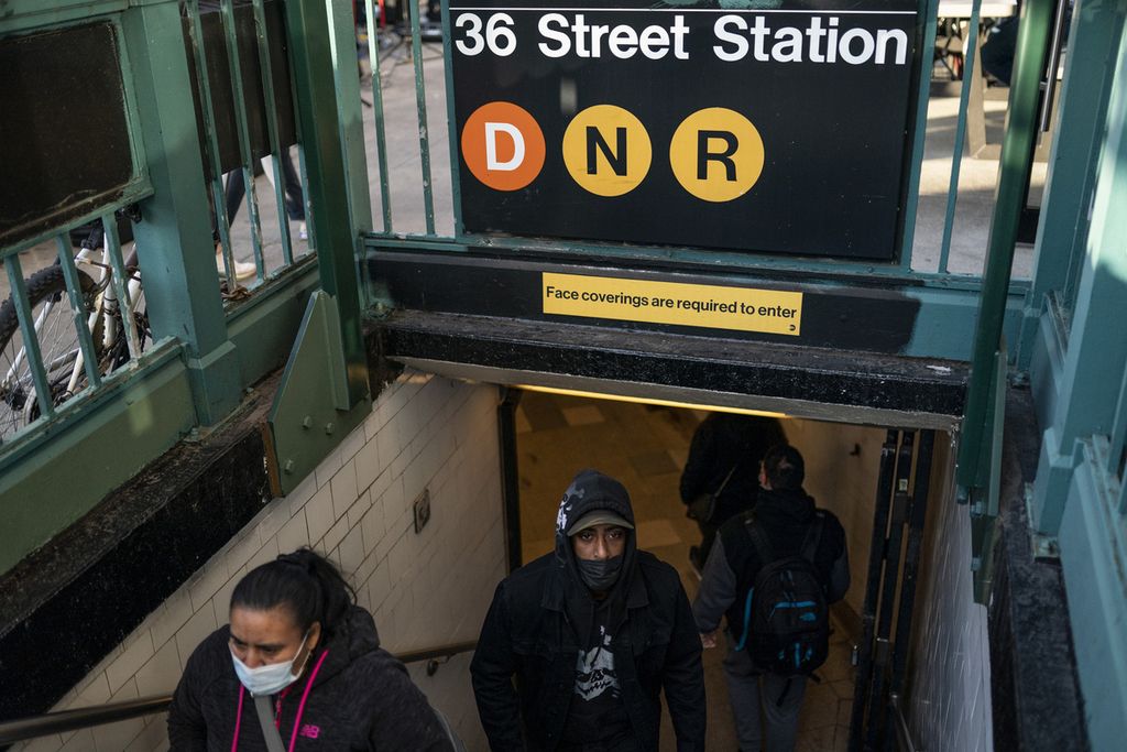 Warga keluar dari stasiun kereta bawah tanah di 36 Street, lokasi penyerangan sehari sebelumnya, Rabu (13/4/2022). Polisi telah menangkap pelaku penembakan di Brooklyn, New York, Amerika Serikat, yang melukai 23 orang. 