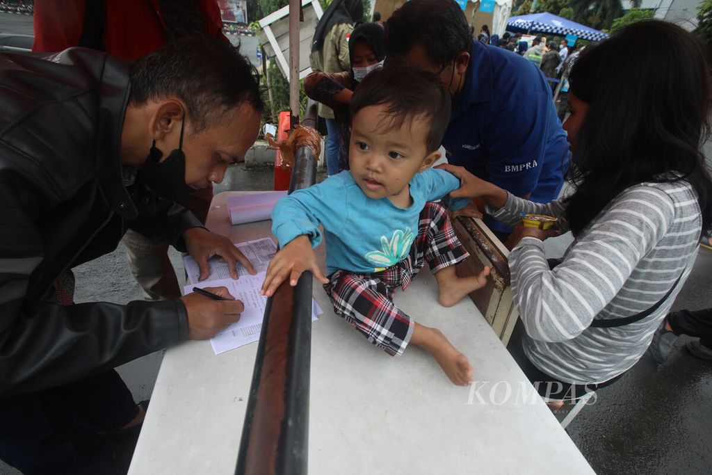 Warga mengisi formulir saat mendaftar Mudik Bareng Polri 2022 di halaman gedung Balai Pertemuan Metro Jaya (BPMJ) di kompleks Mapolda Metro Jaya, Jakarta, Kamis (21/4/2022). 