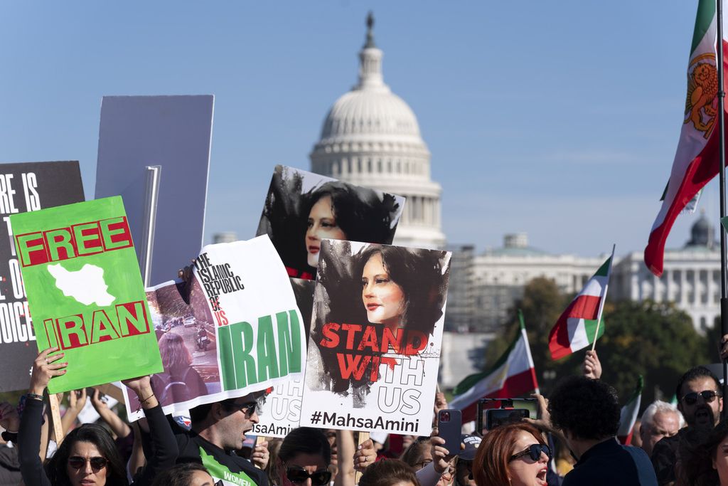 Para pengunjuk rasa dengan membawa foto Mahsa Amini berunjuk rasa di depan National Mall, Washington pada 22 Oktober 2022. Perserikatan Bangsa-bangsa pada Rabu (2/5/2023) menganugerahkan penghargaan kepada tiga wartawan perempuan Iran yang kini tengah ditahan oleh Pemerintah Iran.