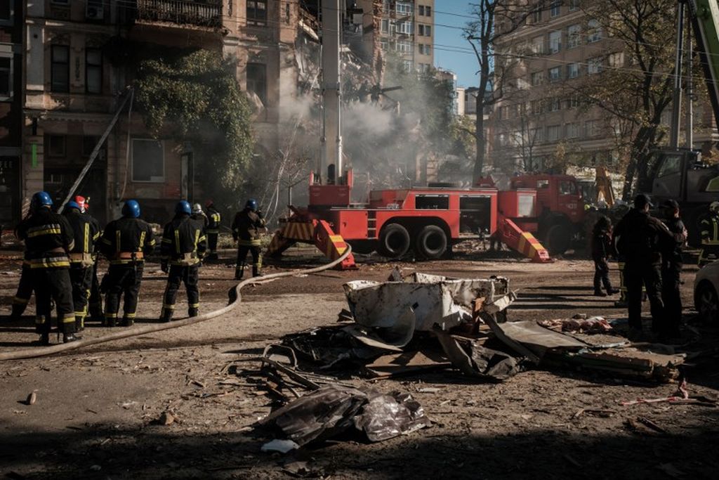 Petugas pemadam kebakaran Ukraina terlihat di lokasi serangan pesawat tak berawak di Kyiv, Ukraina, 17 Oktober 2022, di tengah invasi Rusia ke Ukraina. Pejabat Ukraina mengatakan, pada 17 Oktober 2022, Kyiv empat kali diserang Rusia dengan pesawat tak berawak Iran.