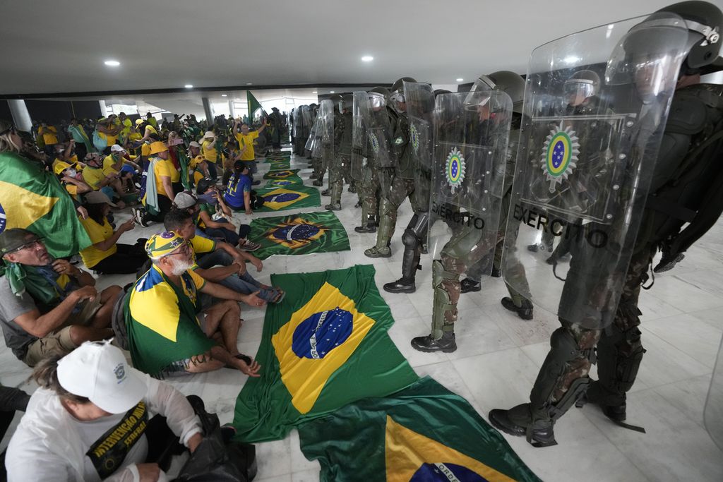 Para pengunjukrasa yang menyerang Istana Kepresidenan Planalto di Brasilia, Brasil, ditangkap Polisi, Minggu (8/1/2023). 