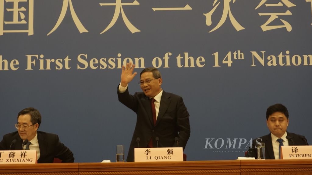 Perdana Menteri China Li Qiang melambaikan tangan sebelum menyampaikan keterangan dalam konferensi pers perdananya setelah dilantik menjadi orang nomor dua China di Aula Besar Rakyat, Senin (13/3/2023).