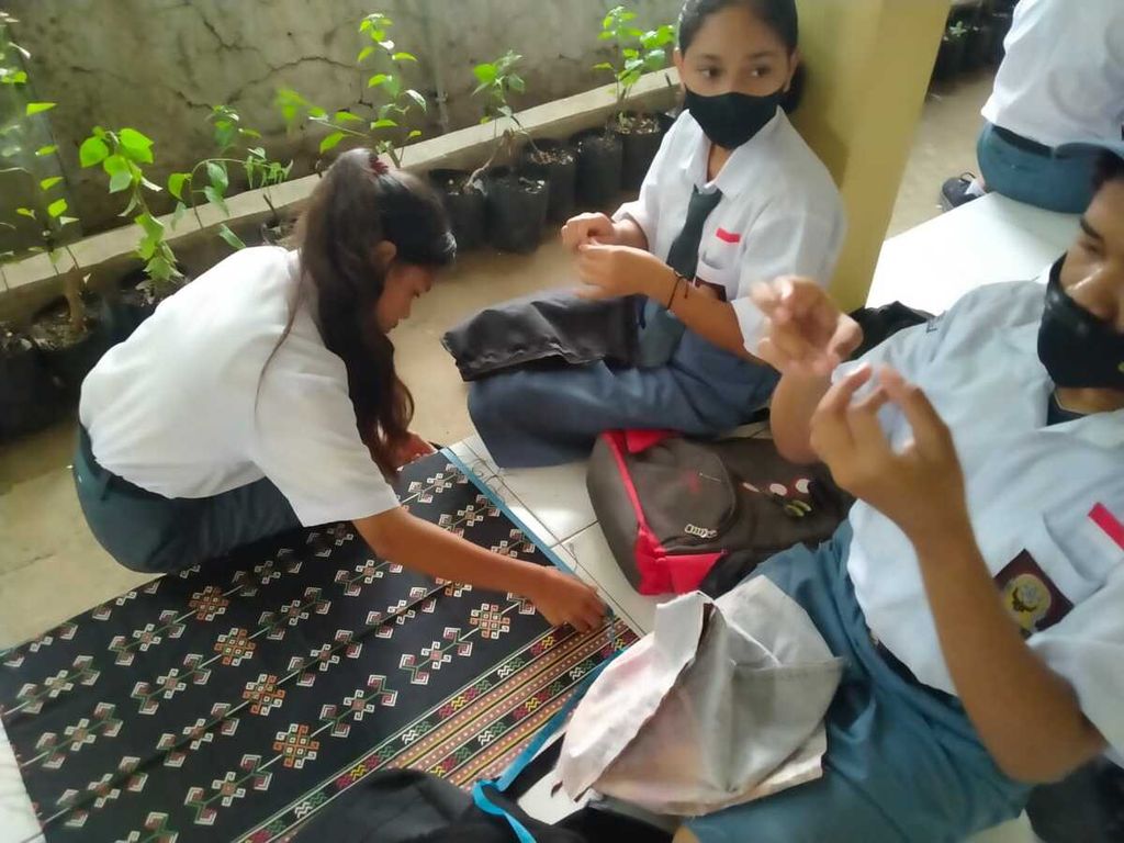 Siswi SMAN 7 Kota Kupang sedang membuat suvenir berupa tas, dompet, dan ikat pinggang dari tenun ikat. Hasil kerajinan mereka jual sendiri kepada orangtua, anggota keluarga, dan dipajang di depan sekolah.