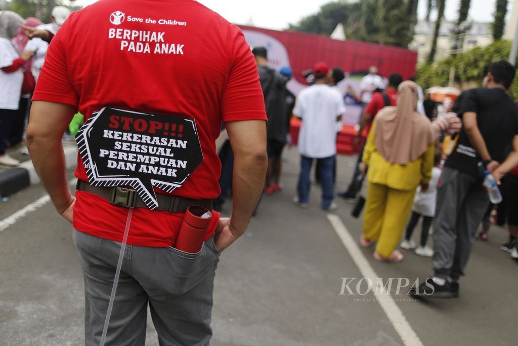 Sambil membawa poster sosialisasi gerakan Stop kekerasan terhadap perempuan dan anak, warga mengikuti acara jalan sehat bersama Menteri Pemberdayaan Perempuan dan Perlindungan Anak Bintang Puspayoga di kawasan Bundaran Hotel Indonesia, Jakarta, Minggu (25/9/2022).