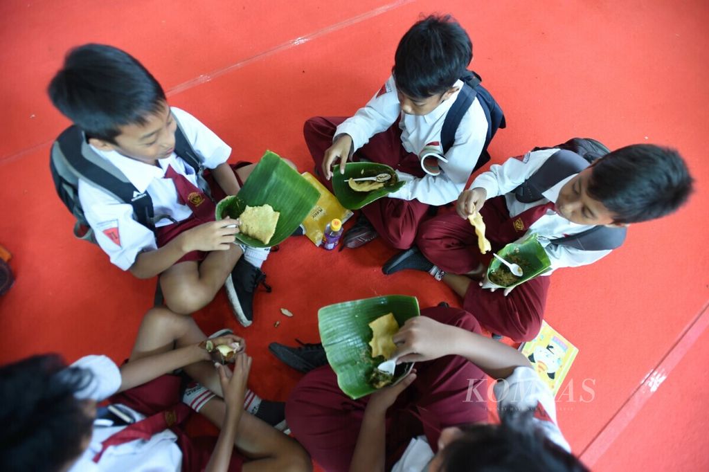 Pelajar makan bersama pecel semanggi yang mereka dapat secara gratis saat saat Pameran peringatan Hari Pangan Sedunia (HPS) Ke-39 tingkat Jawa Timur tahun 2019 di JX International Convention Exhibition Surabaya, Rabu (20/11/2019). 