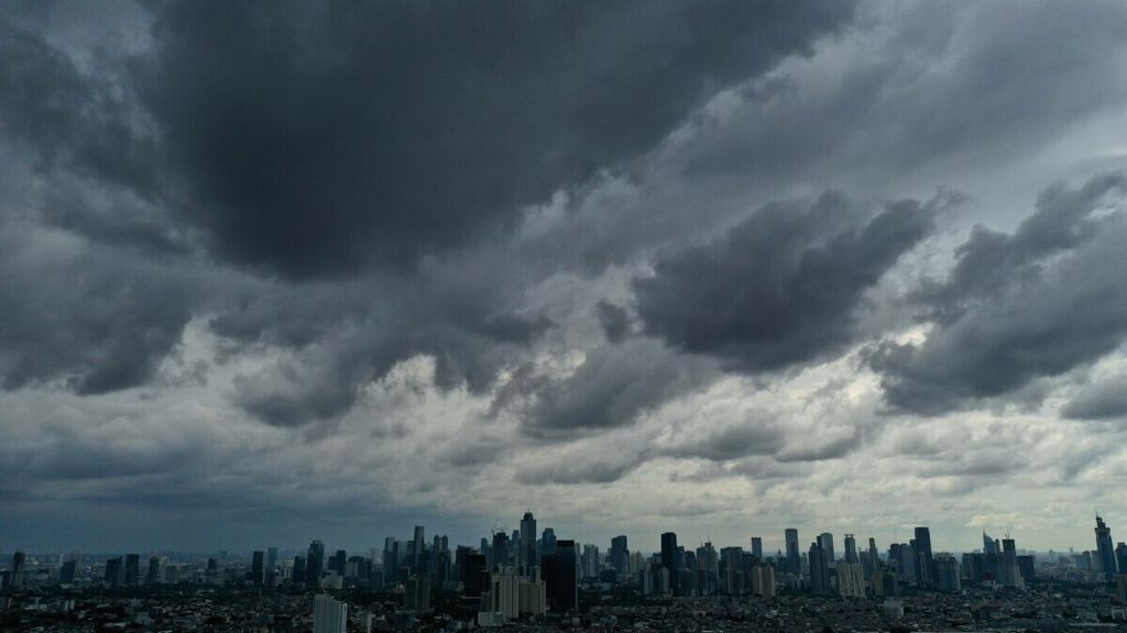 Awan hitam menyelimuti langit Jakarta, Selasa (18/2/2020). BMKG memberi peringatan dini untuk waspada potensi hujan disertai kilat dan angin kencang dengan durasi singkat pada sore hari.