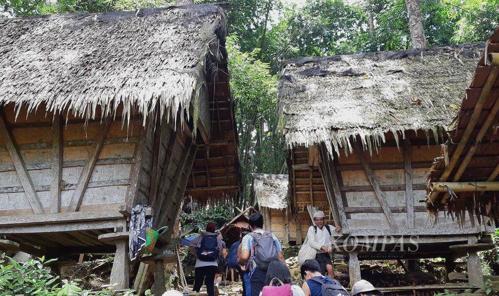Pengunjung berjalan di antara lumbung padi (<i>leuit</i>) di kawasan Baduy Luar, Desa Kanekes, Kecamatan Leuwidamar, Kabupaten Lebak, Banten, Sabtu (10/2/2024). 