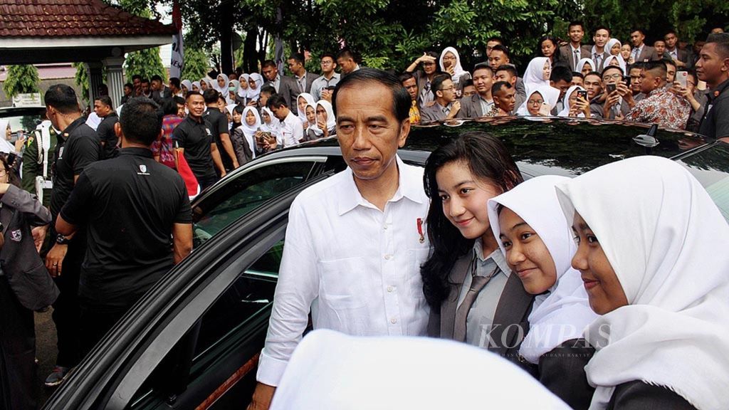 Presiden Joko Widodo berfoto dengan sejumlah siswa SMA Negeri I Palembang setelah membagikan Kartu Indonesia Pintar dan Program Keluarga Harapan di SMA Negeri I Palemnbang, Senin (22/1/2018).  