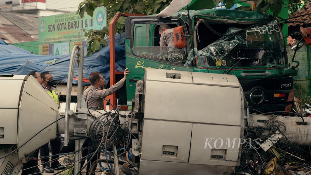 Polisi mengamati tempat duduk sopir dalam kecelakaan truk tronton yang menabrak halte dan menara telekomunikasi di depan SDN Kota Baru II dan III, Jalan Sultan Agung Km 28,5 Bekasi Barat, Kota Bekasi, Jawa Barat, Rabu (31/8/2022). 