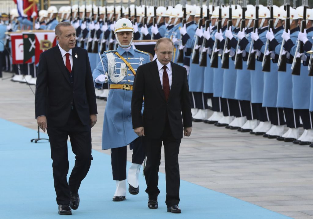 Presiden Turki Recep Tayyib Erdogan (kiri) mengiringi Presiden Rusia Vladimir Putin kala menginpeksi pasukan di Ankara, Turki pada April 2018. Turki semakin dekat ke Rusia. Sebaliknya dengan Amerika Serikat yang sama-sama anggota NATO, hubungan Turki terus memanas