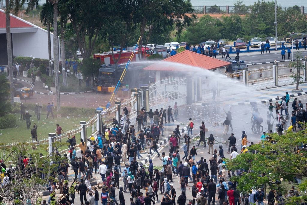 Polisi menggunakan mobil<i> water canon </i>untuk memukul mundur massa yang melempar botol dan batu ke Kantor Badan Pengusahaan Batam, Kepulauan Riau, Senin (11/9/2023).