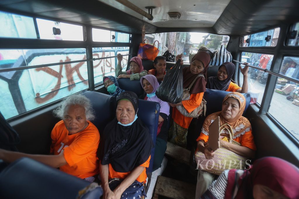 Buruh gendong bersiap menempuh perjalanan pulang dengan menaiki bus di Pasar Beringharjo, Yogyakarta, Senin (6/3/2023). Bus tersebut setiap hari disewa beramai-ramai oleh para buruh gendong yang sebagian besar berasal dari Kecamatan Sentolo, Kulon Progo.