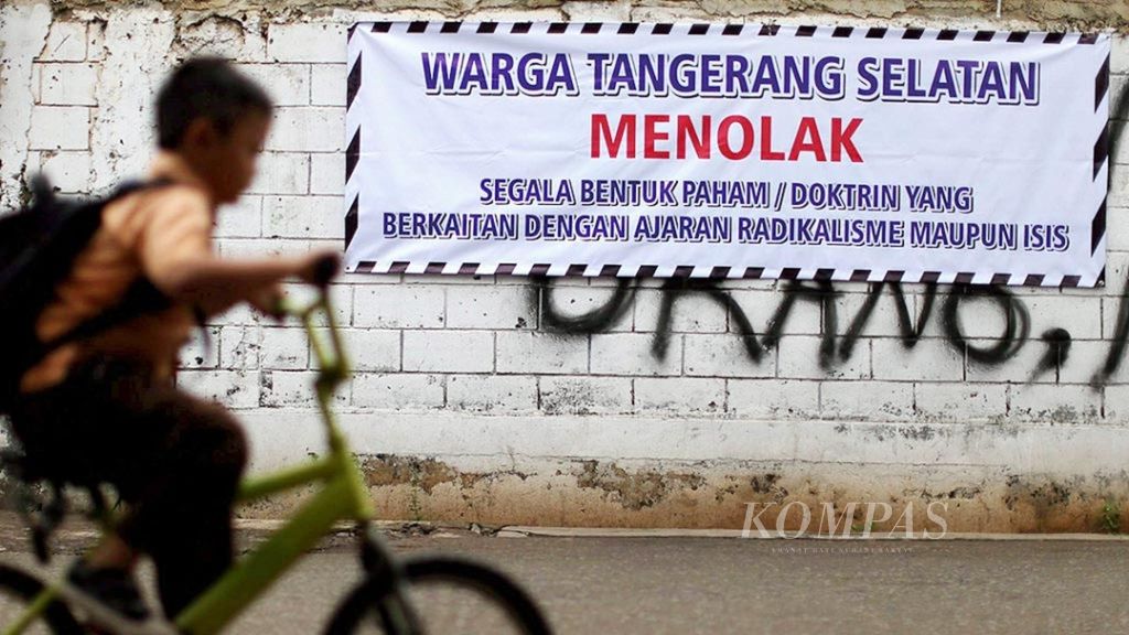 Siswa melintas di depan spanduk menolak radikalisme yang terpampang di kawasan Jurang Mangu, Tangerang Selatan, Banten, Sabtu (23/1). Aksi menolak radikalisme itu merebak setelah teror bom dan penembakan di kawasan Jalan MH Thamrin minggu lalu.