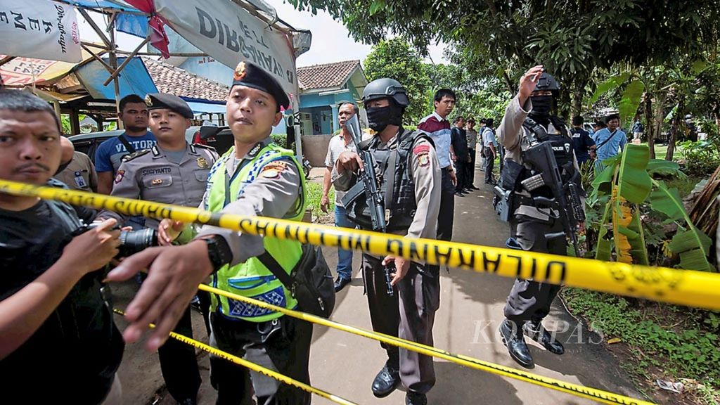 Aparat kepolisian berjaga di sekitar tempat kejadian perkara penggerebekan terduga teroris di RT 002 RW 001, Kelurahan Babakan, Setu, Tangerang Selatan, Banten, Rabu (21/12/2016). Tiga orang terduga teroris tewas dalam penggerebakan tersebut. 
