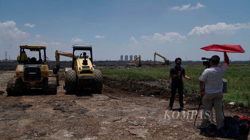 Jurnalis televisi melaporkan langsung persiapan lahan tempat pemakaman jenazah khusus Covid-19 di areal persawahan di Kelurahan Rorotan, Kecamatan Cilincing, Jakarta Utara, Rabu (30/9/2020).