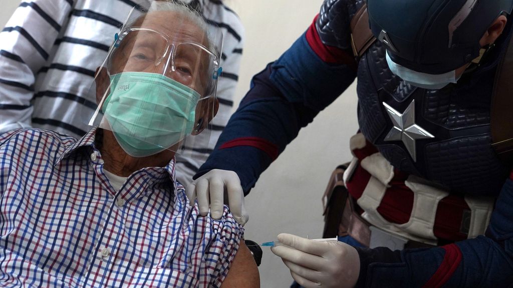 Wirjawan Hardjamulia (104) saat menerima suntikan vaksin Covid-19 ke dua di Rumah Sakit Vania, Kota Bogor, Jawa Barat, yang disuntikan oleh dokter berkostum superhero Captain America, Rollando Erric Manibuy, Selasa (20/4/2021). 