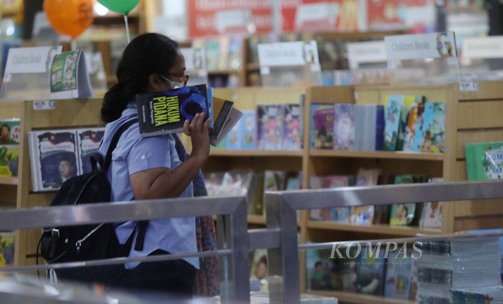 Pengunjung membawa buku yang dipilih saat berbelanja di toko buku Gramedia Matraman, Jakarta, Kamis (2/2/2023). Di tengah derasnya era digital dan kehadiran buku-buku dalam bentuk digital atau elektronik, minat pada buku konvensional masih tetap ada. 