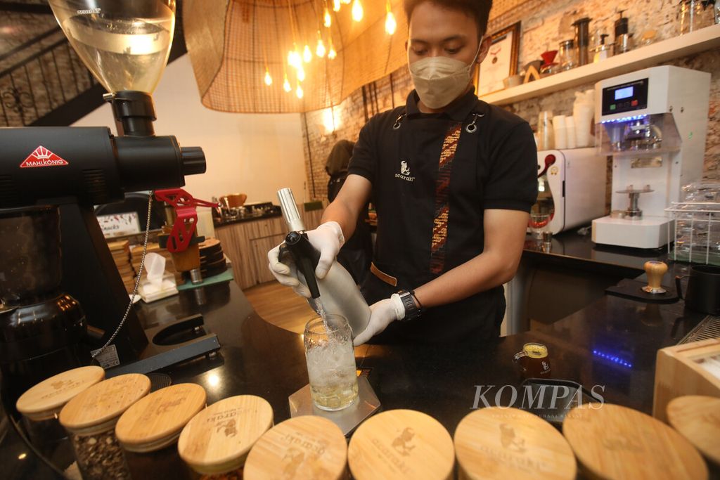 Barista kafe Jamu Acaraki di kawasan Kota Tua, Jakarta, meracik jamu, Kamis (19/5/2022).