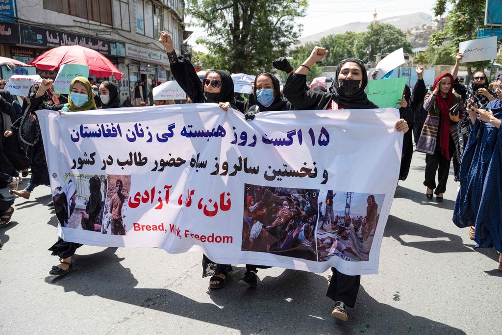 Perempuan Afghanistan membentangkan spanduk bertuliskan roti, kerja, kebebasan dalam unjuk rasa di Kabul, Afghanistan, Sabtu (13/8/2022).