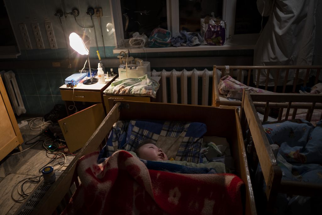 Di bawah temaram lampu, seorang bayi tertidur di sebuah boks bayi di Rumah Sakit Ibu dan Anak di Kherson, Ukraina selatan, Selasa (22/10/2022). Lembaga Save Ukraine, awal April, memulangkan lebih dari 30 anak Ukraina yang dibawa oleh Rusia ke Krimea. 