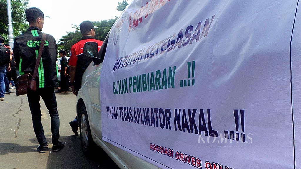Pengemudi angkutan  daring berunjuk rasa di depan Kantor Gubernur Jawa Tengah, Kota Semarang, Senin (18/12). Mereka menuntut agar profesinya dilindungi payung hukum dan ada kemitraan yang adil antara pengemudi dan  perusahaan penyedia  aplikasi.