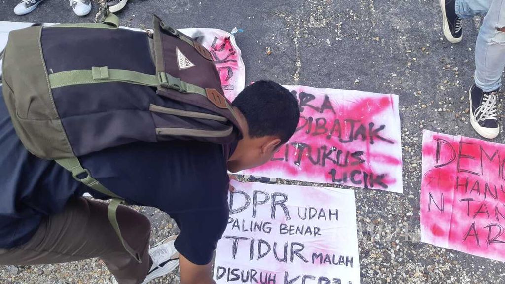 Mahasiswa Aliansi Rakyat Melawan menaruh spanduk dan baliho yang mereka buat dalam unjuk rasa di halaman gedung kantor DPRD Kalimantan Tengah, Jumat (23/8/2024). Mereka meminta DPRD Kalteng punya sikap soal RUU Pilkada dan mengikuti putusan Mahkamah Konstitusi.