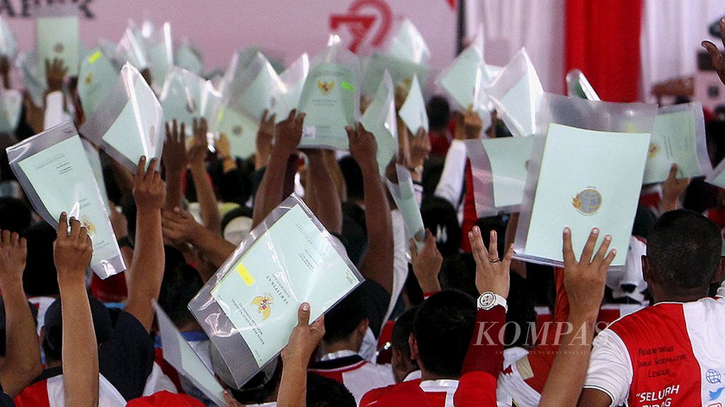 A number of residents hold their land certificates during the submission of certificates of land rights throughout the Greater Jakarta area in Jakarta, Sunday (20/8/2017).