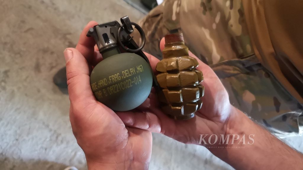 Ilustrasi. Seorang milisi pro-Ukraina menunjukkan granat di gudang penyimpanan senjata di bagian selatan Ukraina, 22 Juni 2022. 