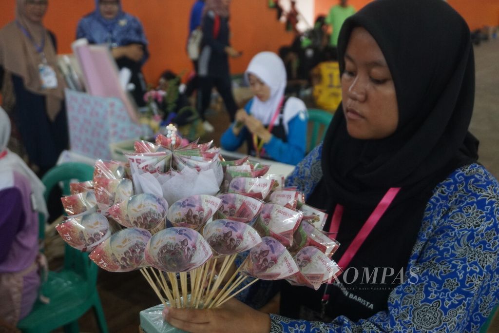 Pelajar SLB membuat buket dari uang tiruan dalam Lomba FLS2N, LKSN, dan O2SN Sekolah Luar Biasa Cabang Dinas Pendidikan Wilayah X di GOR Satria, Purwokerto, Banyumas, Jawa Tengah, Selasa (30/4/2024).