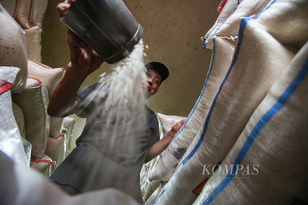 Pedagang mempersiapkan beras di tokonya di pasar Kebayoran Lama, Jakarta Selatan, Selasa (13/2/2024).  