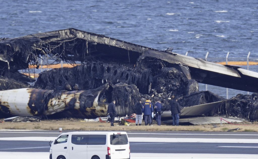 Penyelidik memeriksa puing pesawat Japan Airlines di  Bandara Haneda, Jepang, pada Kamis (4/1/2024). Pesawat terbakar setelah bertabrakan dengan pesawat Penjaga Pantai Jepang pada selasa lalu.