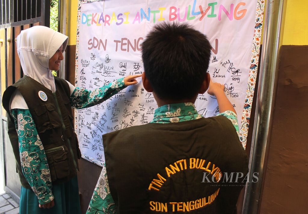 Tim Satgas Antibullying Sekolah Dasar Negeri Tenggulunan, Kabupaten Sidoarjo, Jawa Timur, menunjukkan deklarasi <i>antibullying </i>di sekolah itu, Rabu (4/10/2023). Satgas ini bertugas memantau tindakan perundungan di sekolah, seperti mengolok, mengejek nama orangtua dengan kata-kata kasar, dan mengancam.