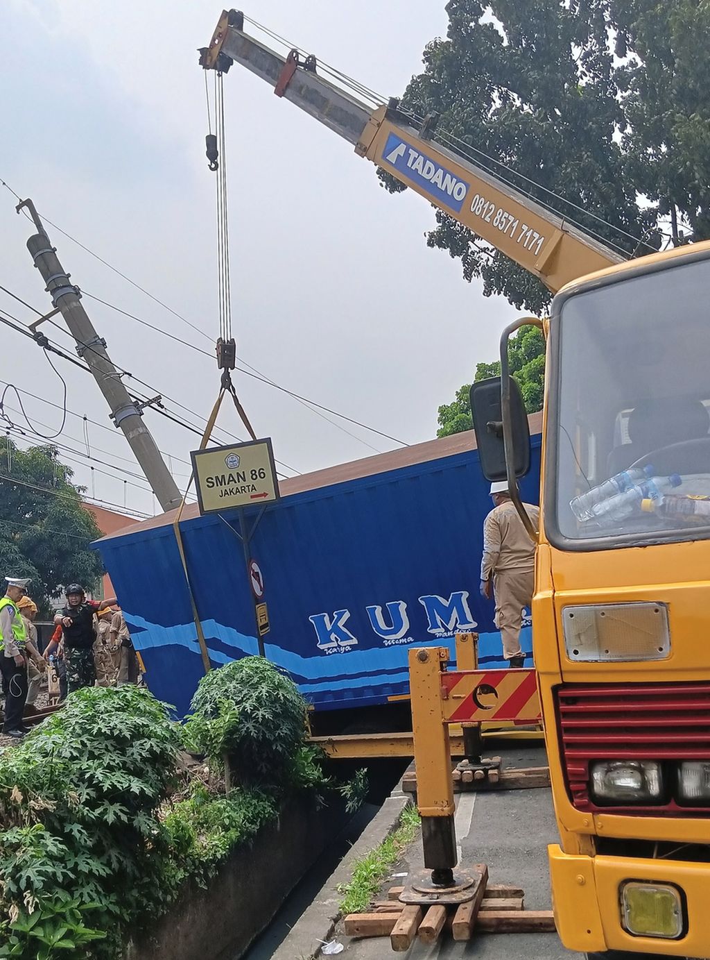 Truk <i>crane </i>saat mengevakuasi truk barang yang menabrak tiang listrik aliran atas (LAA) di jalur rel listrik di Km 17+5 antara Stasiun Pondok Ranji dan Kebayoran, Jalan Bintaro Permai IV, Pesanggrahan, Jakarta Selatan, Selasa (25/7/2023).