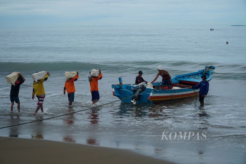Nelayan di Kelurahan Pasie Nan Tigo, Kecamatan Koto Tangah, mengangkut es batu untuk stok mengawetkan ikan selama sepekan melaut di perairan Kota Padang, Sumatera Barat, Sabtu (3/9/2022) jelang siang. Nelayan kapal bagan ini kembali melaut seeusai lima hari terpaksa libur akibat cuaca buruk.