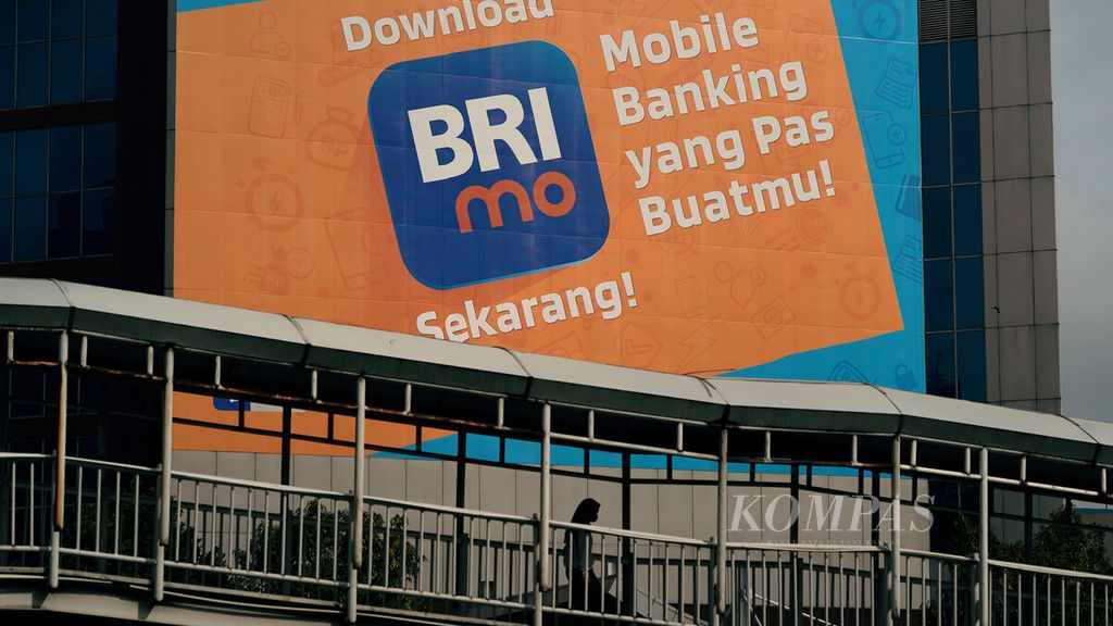 Warga melintasi baliho ajakan untuk mengunduh aplikasi digital BRI di Jalan Sudirman, Jakarta Pusat, Minggu (6/2/2022). PT Bank Rakyat Indonesia (Persero) Tbk atau BRI membukukan laba bersih Rp 32,22 triliun pada 2021 atau tumbuh 75,53 persen dibandingkan dengan tahun sebelumnya. 