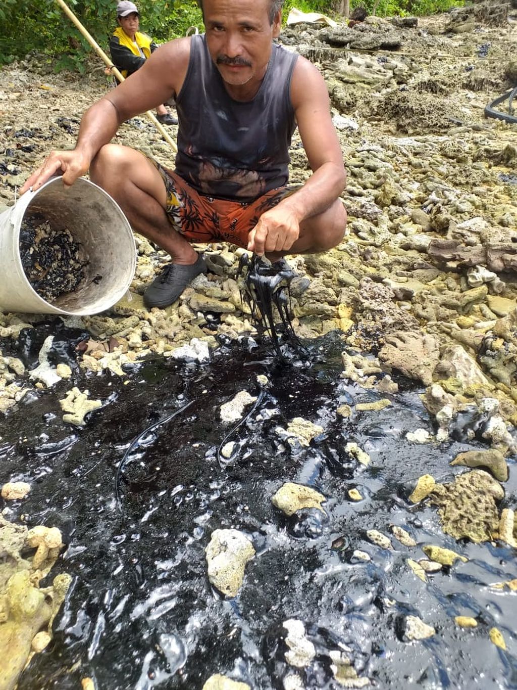 Nelayan menunjukkan gumpalan aspal di pantai perairan Kabupaten Nias Utara, Sumatera Utara, Rabu (1/3/2023). Sudah tiga pekan tanker yang kandas menumpahkan muatan 1.900 ton aspal di Nias Utara sehingga merusak ekosistem laut.