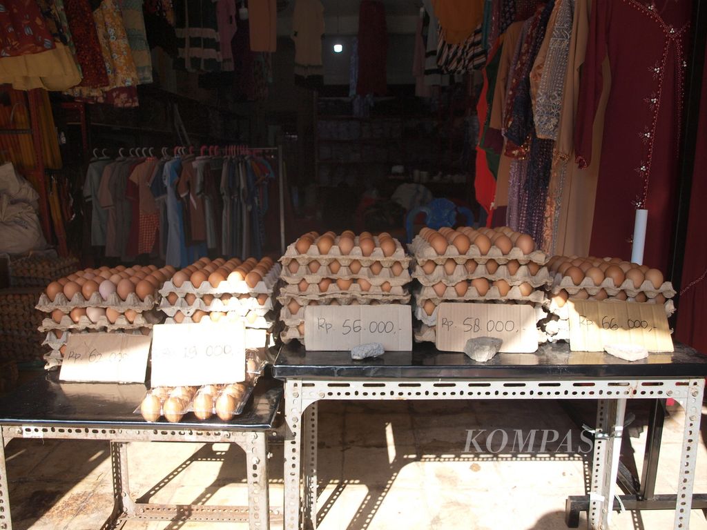 Telur ayam dipajang di muka sebuah toko baju, Jumat (26/8/2022), di Wenang, Manado, Sulawesi Utara. Harga telur ayam naik signifikan bagi para pedagang, hingga Rp 5.000 per baki berisi 30 butir.