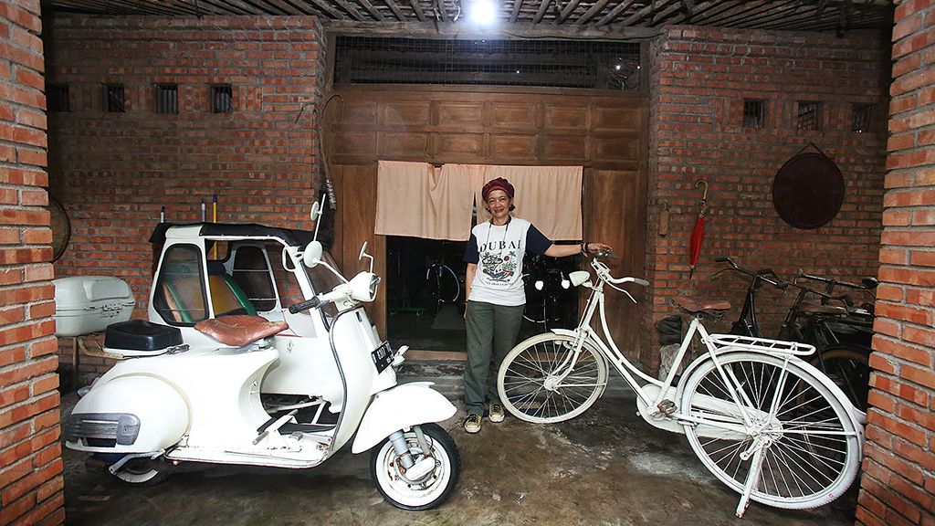 Perupa Yani Mariyani Sastranegara bersama sebagian koleksi Vespa dan sepeda ontelnya di studionya di kawasan Jombang, Ciputat, Banten, Kamis (1/2).