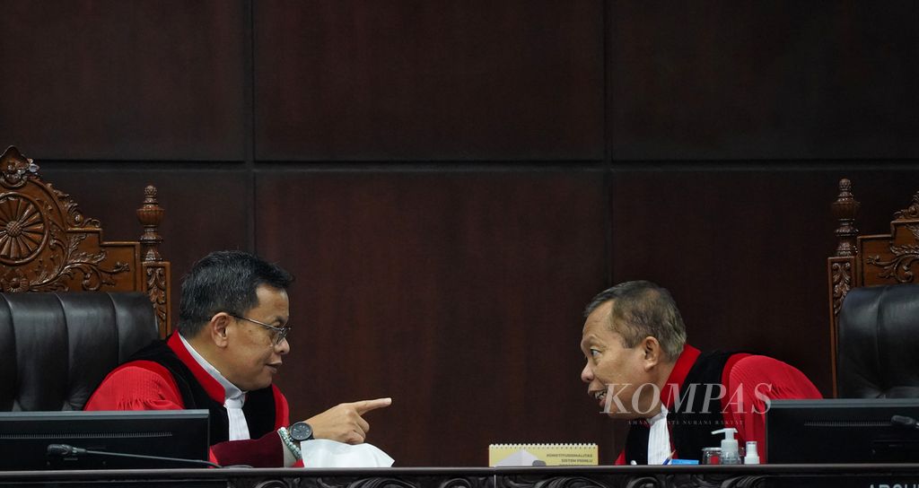 Hakim Konstitusi Guntur Hamzah dan Arsul Sani berdialog sejenak diantara rangkaian sejumlah agenda sidang putusan di Mahkamah Konstitusi, Jakarta, Kamis (29/2/2024).