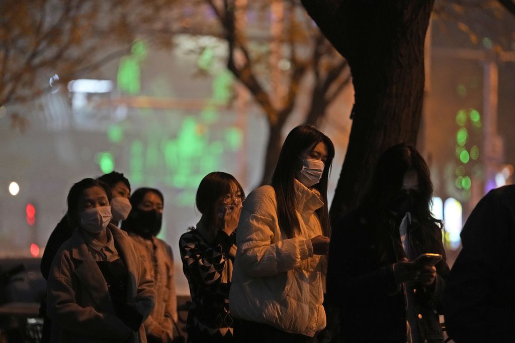 Warga mengantre untuk mengikuti tes Covid-19 di jalan di kota Beijing, 22 November 2022. 