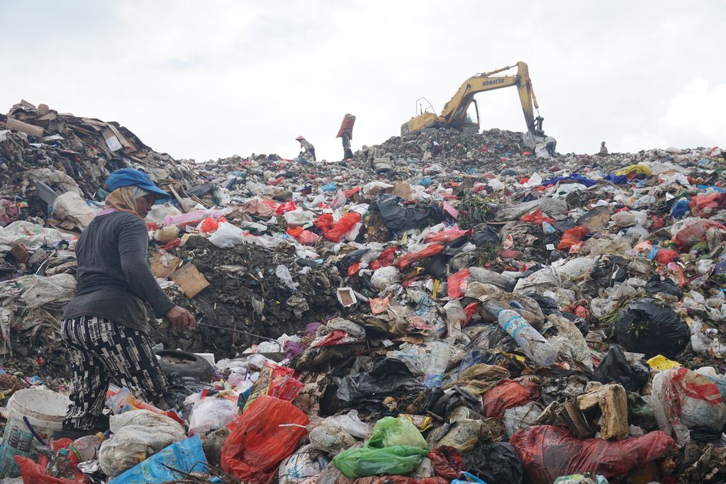 Petugas sampah bekerja di kaki gunungan sampah, Jumat (18/9/2020), di Tempat Pembuangan Akhir Sumompo, Kota Manado, Sulawesi Utara.