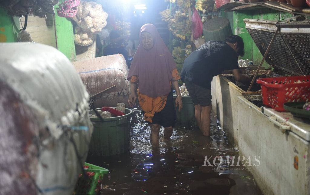 Pedagang beraktivitas di Pasar Wadungasri yang tergenang banjir di Kecamatan Waru, Sidoarjo, Rabu (7/2/2024). Banjir di pasar tersebut telah berlangsung selama dua hari. Kejadian tersebut membuat banyak pedagang memilih tidak berjualan. 