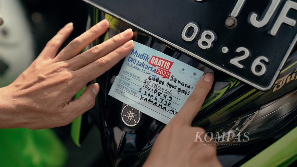 Petugas menempelkan stiker Mudik Gratis di sepeda motor yang akan diangkut dengan truk secara gratis di Terminal Pulogadung, Jakarta Timur, Selasa (26/4/2022).