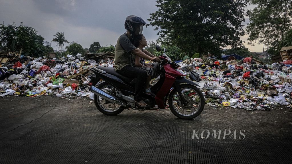 Warga melintasi tumpukan sampah di tempat pembuangan sampah sementara di Jalan Babakan Tengah, Dramaga, Kabupaten Bogor, Jawa Barat, Senin (21/2/2022). Setiap tanggal 21 Februari diperingati sebagai Hari Peduli Sampah Nasional. Selain rendahnya kesadaran pengelolaan sampah yang baik, volume sampah yang tinggi di setiap sudut kawasan permukiman tak lepas dari kebiasaan konsumsi masyarakat yang berlebih. Hal ini pada akhirnya menyisakan residu dan berdampak bagi lingkungan.