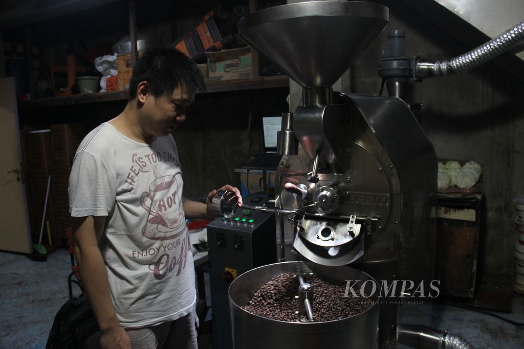 Heri Wonoto (41), pemilik warung kopi Winny, di Kota Pontianak, Kalimantan Barat, mengolah biji kopi, Selasa (13/6/2023).