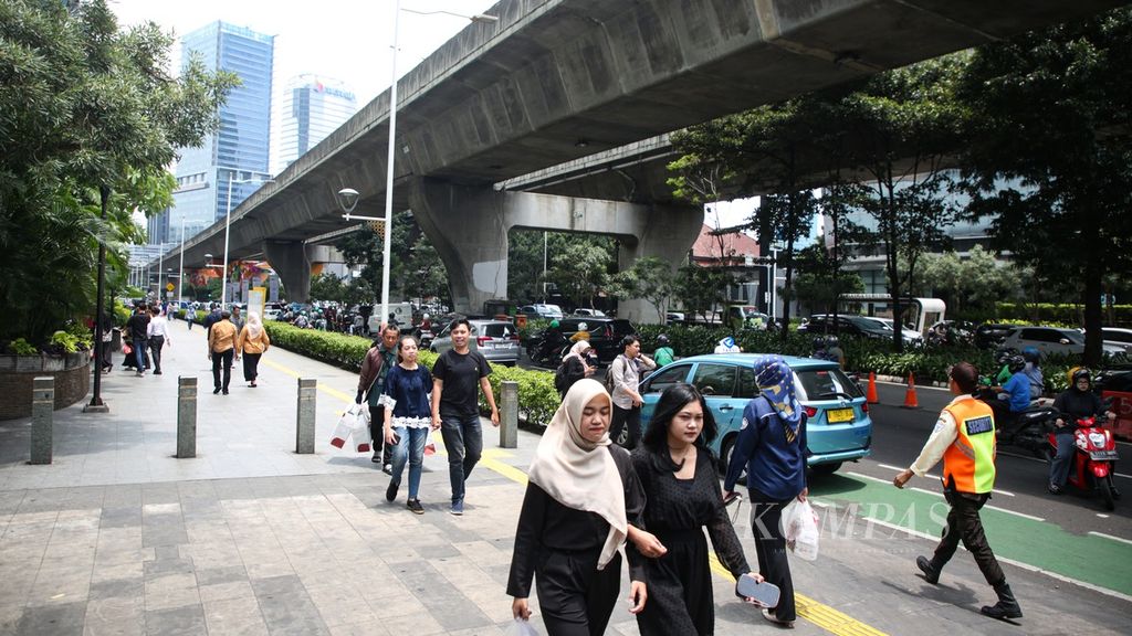 Karyawan melintas di area pedesterian di kawasan Kuningan, Jakarta Selatan, saat jam makan siang, Selasa (27/2/2024). 