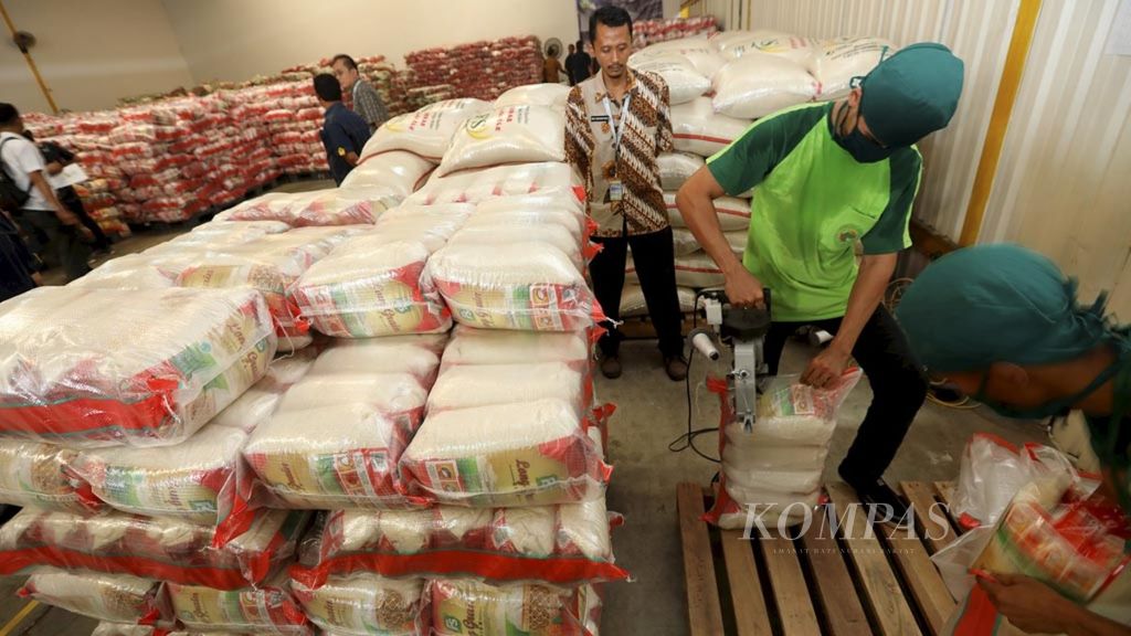 Pekerja mengepak beras di gudang pengemasan PT Food Station Tjipinang Jaya di Cipinang, Jakarta Timur, Rabu (17/5/2023).  