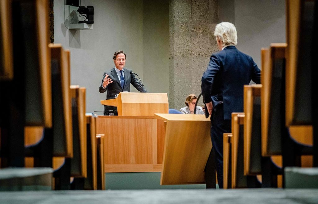 Perdana Menteri Belanda Mark Rutte (kiri) berbicara dengan tokoh oposisi sayap kanan, Ketua Partai PVV Geert Wilders, dalam sidang di DPR Belanda di Den Haag, Belanda, 19 Januari 2022. 