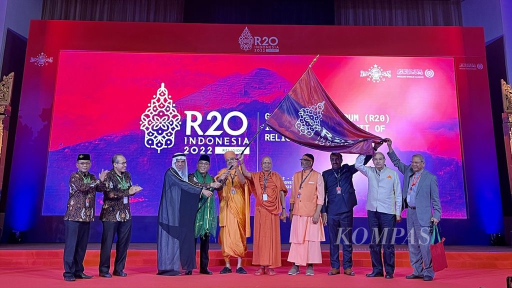 Ketua Umum Pengurus Besar Nahdlatul Ulama KH Yahya Cholil Staquf (keempat dari kiri) mengibarkan bendera G20 Religion Forum atau R-20 bersama sejumlah tokoh agama dari India saat penutupan Forum R-20 di Nusa Dua, Bali, Kamis (3/11/2022). India akan menjadi tuan rumah R-20 pada 2023.